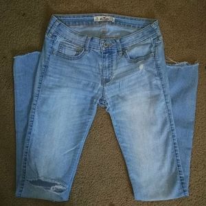 Light denim jeans distressed rip on one pant leg